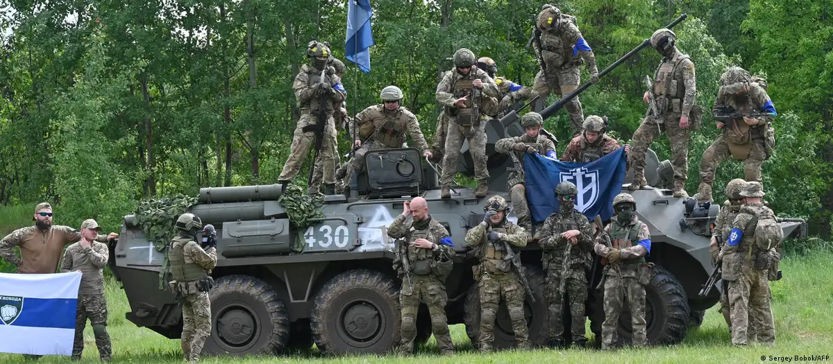 Fighters from the "Freedom of Russia" legion in front of a captured Russian military vehicle